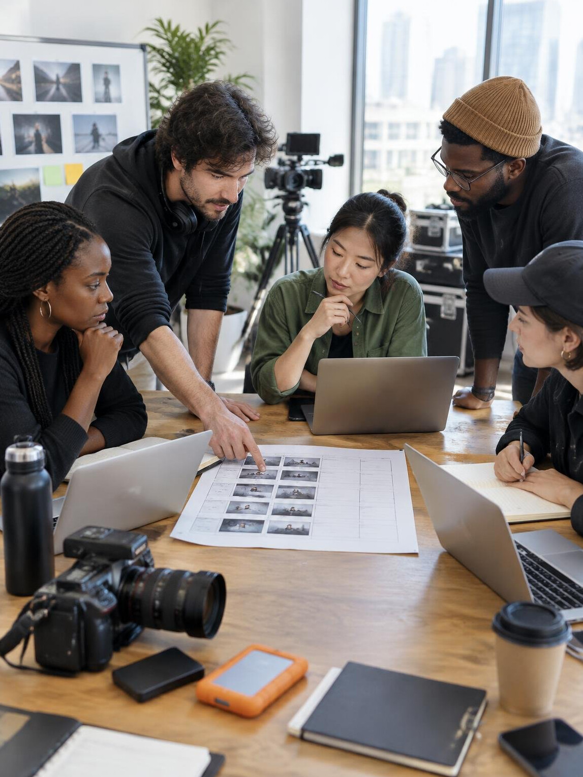 Production team planning around a table with laptops